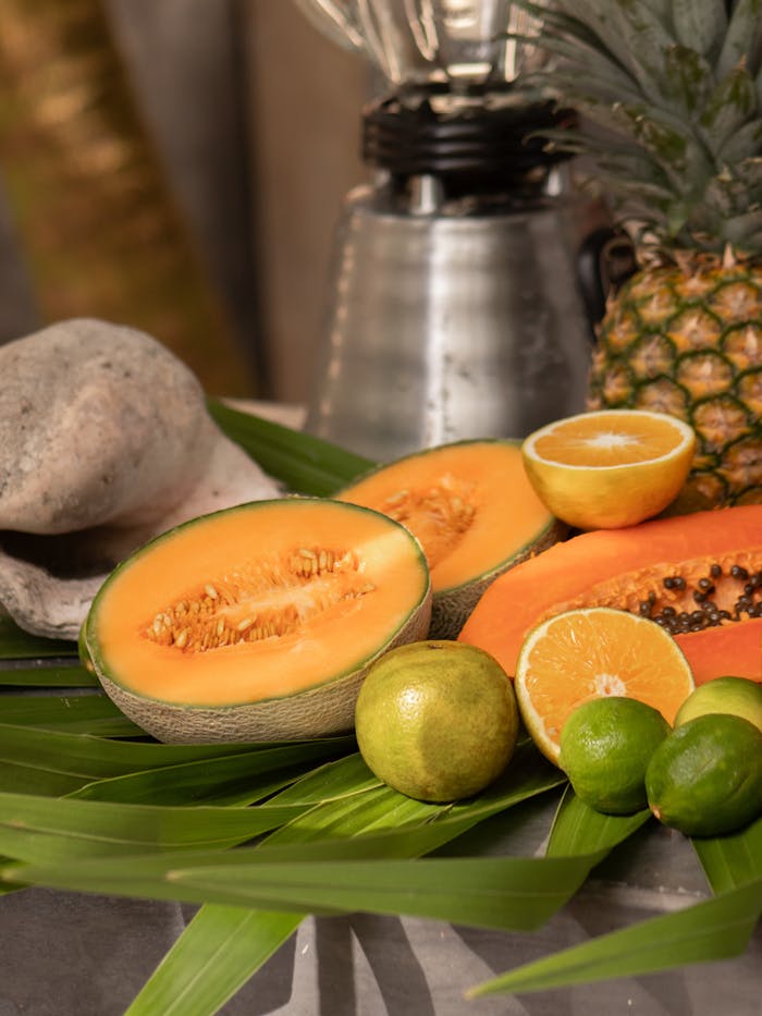 stats-img Colorful display of tropical fruits with a blender in a natural setting.