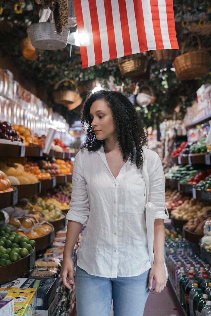 Crafting Captivating Headlines: Your awesome post title goes here Woman browsing fresh fruits and vegetables in supermarket aisle with American flag decor above.